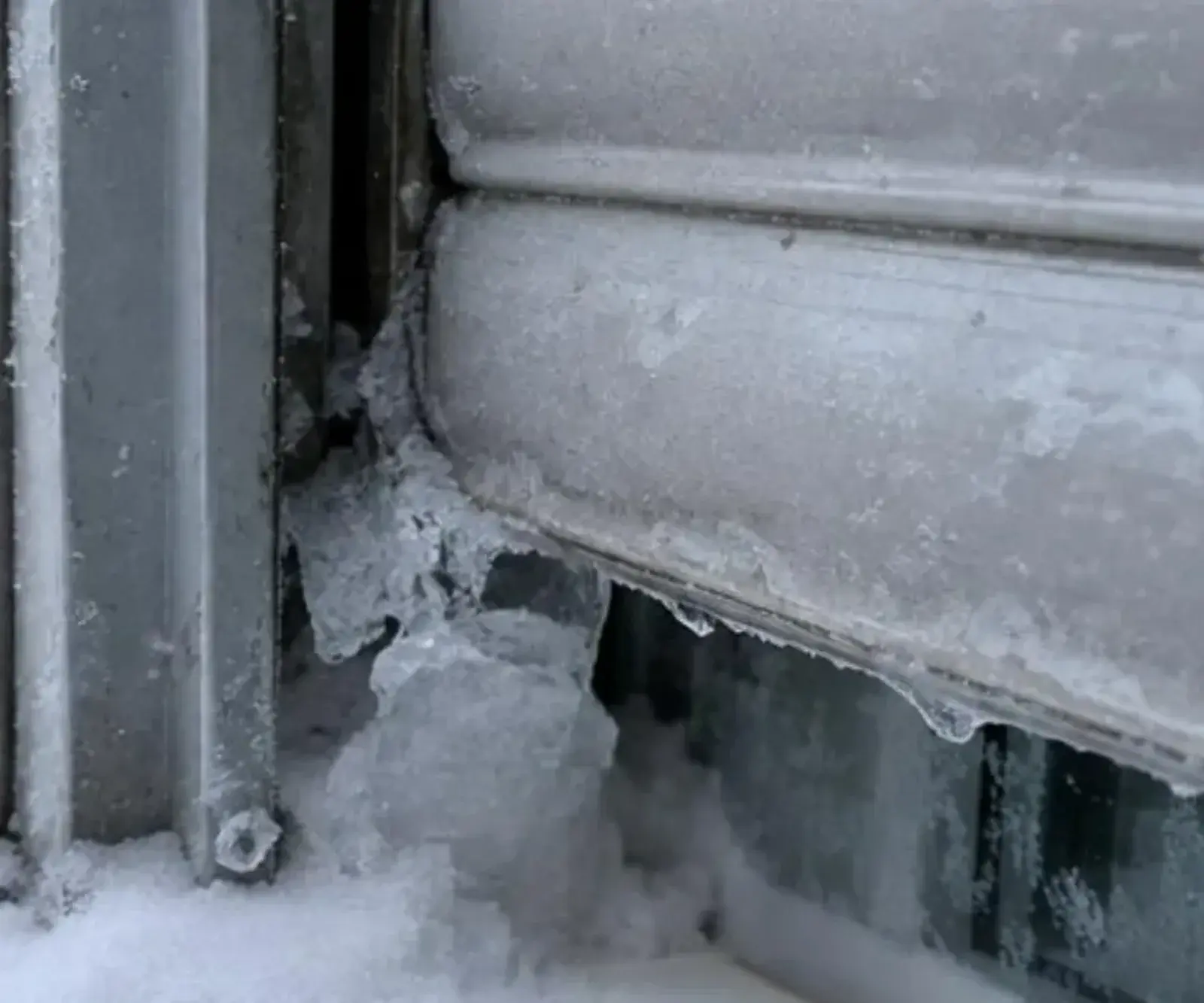 Coulisse de volet roulant prise par la glace en bas de fenêtre